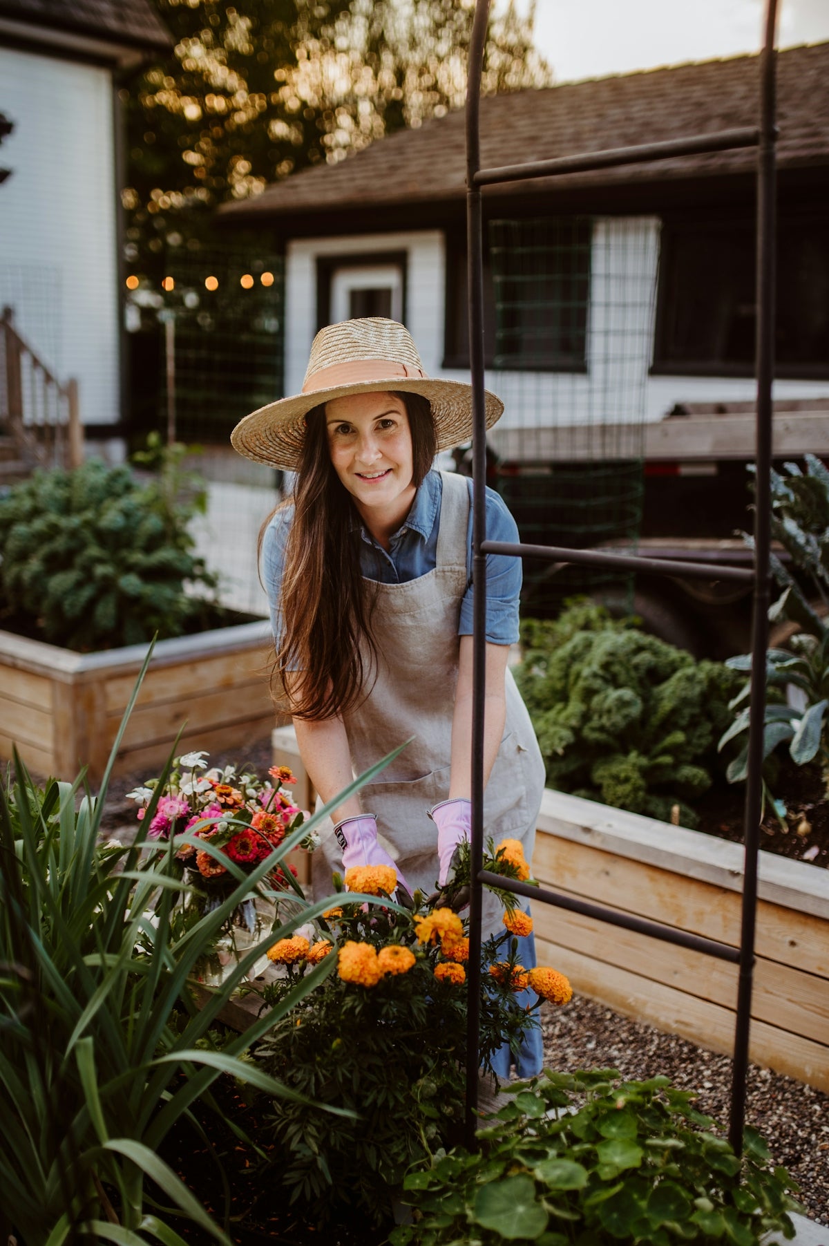 A woman wearing a hat and gardening gloves